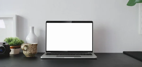 Tiro recortado de computador portátil de tela em branco aberto com material de escritório e espaço de cópia na sala de escritório moderna — Fotografia de Stock