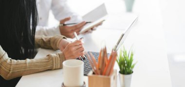 Masayı kullanırken genç profesyonel iş adamlarının şu anki projelerini tartışırken çekilmiş görüntüleri.