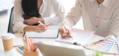 Ofis odasında boş ekran tableti kullanırken projeyi tartışan genç profesyonel tasarımcının yakın plan görüntüsü 