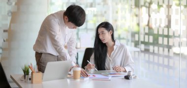 Genç tasarımcı ekibinin modern iş yerinde projelerini birlikte planlarken çekilmiş görüntüleri.