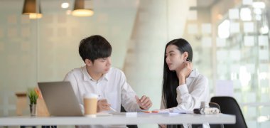 Genç profesyonel grafik tasarımcı takımı modern işyerinde kavramları tartışıyor.