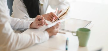 Genç profesyonel grafik tasarımcı ekibinin tabletle kavramları tartışırken yakın plan görüntüsü 