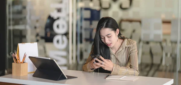 Young professional female designer working on her project while using digital tablet in modern office room — Stock Photo, Image