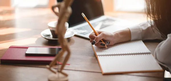 Vue rapprochée d'une femme d'affaires professionnelle travaillant sur son projet tout en écrivant sur un carnet — Photo