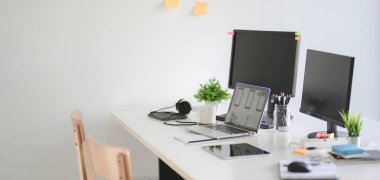 Beyaz masadaki modern Ux web geliştirici takım işyeri bilgisayarının ve dizüstü bilgisayarının kırpılmış görüntüsü  