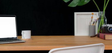 Dizüstü bilgisayar, ofis malzemeleri ve ahşap masa ve siyah arkaplan üzerinde kopyalama alanı olan modaya uygun çalışma alanı. 