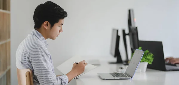 Jonge professionele Ui webontwikkelaar werkt aan zijn project met laptop computer op moderne werkplek — Stockfoto