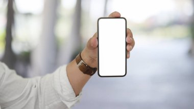 Bulanık ofis geçmişine sahip boş ekran akıllı telefonunu gösteren bir iş adamı görüntüsü. 