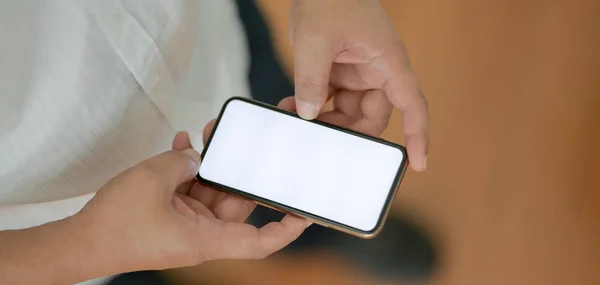 Vista close-up do empresário tocando smartphone tela em branco enquanto está em pé na sala de escritório — Fotografia de Stock