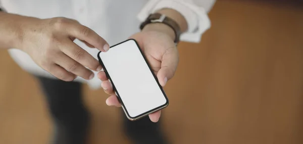Närbild av mannen med hjälp av blank skärm smartphone när du står i sitt kontor rum — Stockfoto
