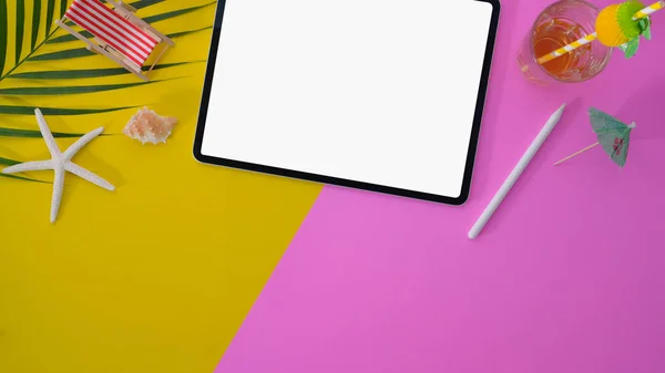 Colourful summer workspace with blank screen digital tablet on pink and yellow desk background