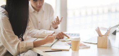 Tablet kullanırken projelerini tartışan genç ve başarılı grafik tasarımcı ekibinin yakın plan görüntüsü 