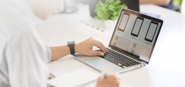Akıllı telefon şablonu üzerinde bilgisayarla çalışan tutkulu genç Ux web geliştirme görüntüsü. 