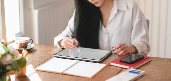 Schnappschuss einer jungen schönen Geschäftsfrau, die im gemütlichen Büroraum an ihrem Projekt mit Tablet arbeitet — Stockfoto