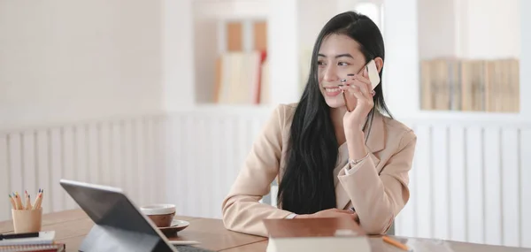 Обрізаний знімок бізнес-леді, що говорить по телефону зі своїм клієнтом у зручному робочому місці — стокове фото