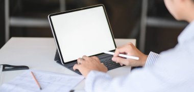Profesyonel mimarın dijital tabletle inşaat planı üzerinde çalışırken çekilmiş görüntüleri. 