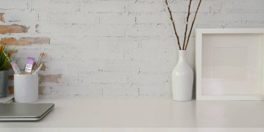 Model çerçeveli rahat iş yeri, ofis malzemeleri ve beyaz masadaki kopyalama alanı.