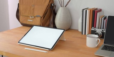 Boş ekran dijital tabletle ahşap masada rahat bir ofis odası görüntüsü. 