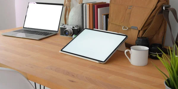 Крупный план уютного рабочего места фотографа с макетом цифрового планшета и ноутбука с офисными принадлежностями на деревянном столе — стоковое фото