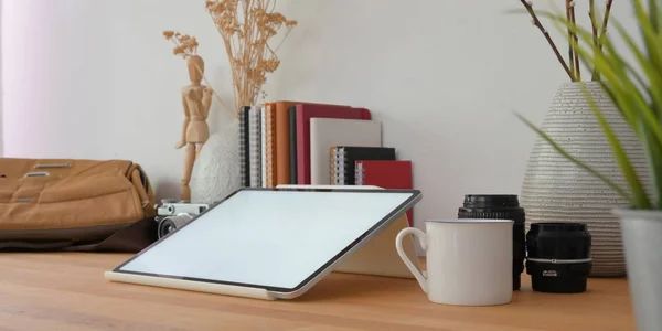 Vista de perto do espaço de trabalho do fotógrafo profissional com tablet mock up e material de escritório na mesa de madeira — Fotografia de Stock