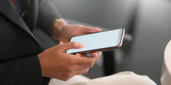 Plan recadré de jeune femme d'affaires travaillant avec un smartphone vierge dans la salle de bureau — Photo