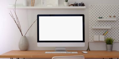 Boş ekran masaüstü bilgisayarı ve ahşap masadaki ofis malzemeleri ile rahat çalışma alanı