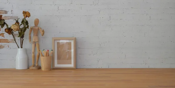 Plan recadré d'un lieu de travail vintage avec un cadre maquillé et un espace de copie sur une table en bois et un fond mural en brique — Photo