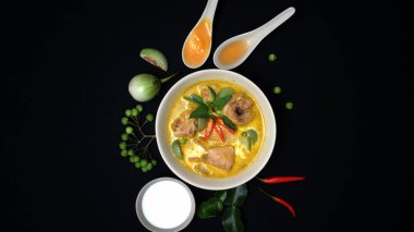 Yeşil körili tavuk ve siyah masa arkasındaki malzemeler, Tayland mutfağı konsepti.