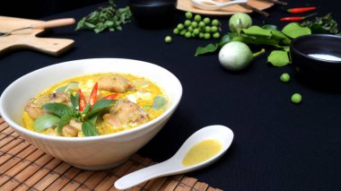 Kesilmiş tavuk yeşili köri ve siyah masa arkasında malzemeler, Tayland mutfağı konsepti.