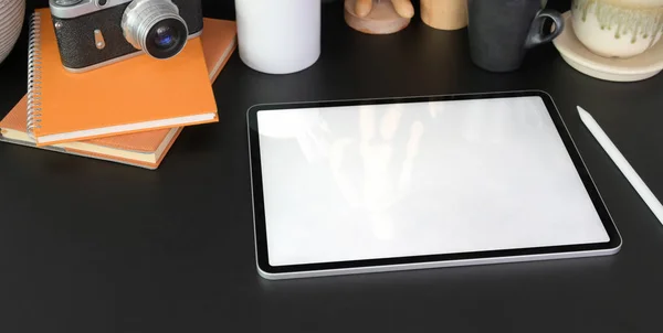 Plan recadré d'une tablette vierge dans une pièce de bureau moderne sombre avec des fournitures de bureau sur une table noire — Photo