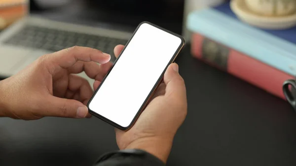 Vista de cerca del joven hombre de negocios utilizando el teléfono inteligente de pantalla en blanco en la habitación oscura oficina moderna — Foto de Stock