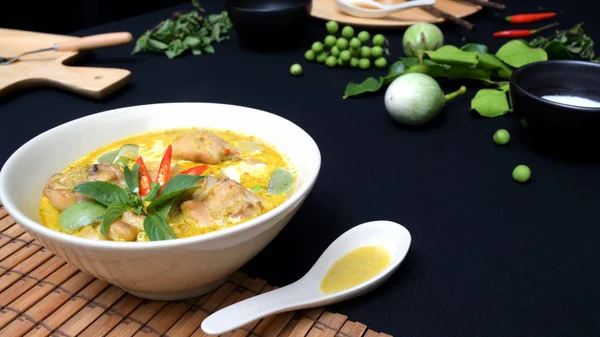 Kesilmiş tavuk yeşili köri ve siyah masa arkasında malzemeler, Tayland mutfağı konsepti.