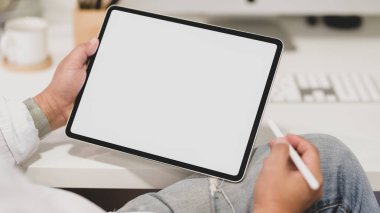 Boş ekran tableti kullanırken genç işadamının projesi üzerinde çalışırken çekilmiş görüntüleri.