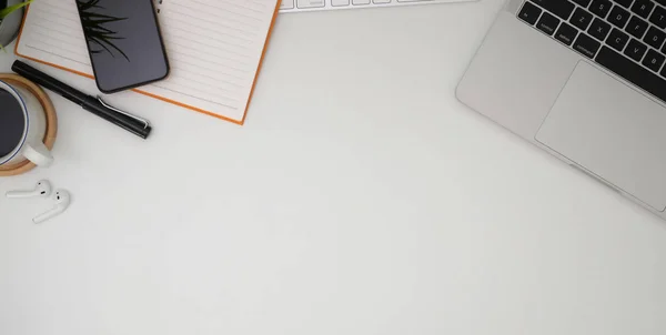 Foto aerea del posto di lavoro alla moda con computer portatile, forniture per ufficio e spazio copia su tavolo in legno bianco — Foto Stock