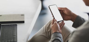 Boş ekran akıllı telefon kullanan genç iş adamının kırpılmış görüntüsü