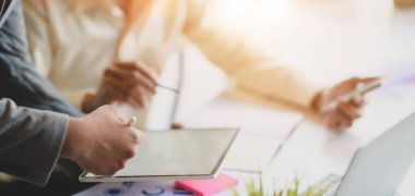 Ofis odasında tablet kullanırken projelerinde çalışan iki genç iş adamının görüntüsü. 