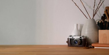 Ofis malzemeleri ve ahşap masa üzerindeki fotokopi alanının olduğu rahat iş yerinin yakın görüntüsü