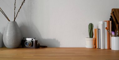 Ofis malzemeleri ve ahşap masa üzerindeki fotokopi alanının olduğu rahat iş yerinin yakın görüntüsü