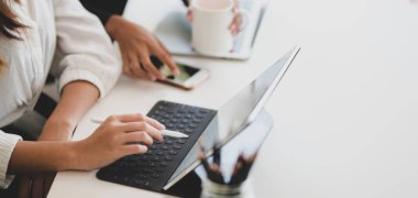 Tablet kullanırken projeyi tartışan genç iş kadınlarının kırpılmış görüntüleri 