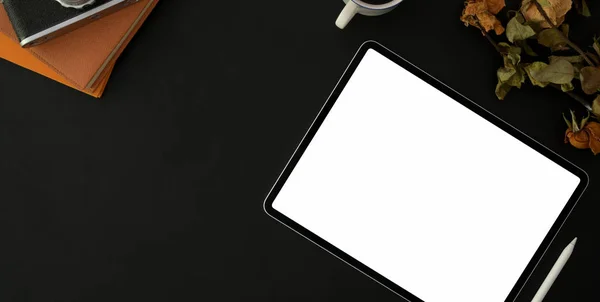 Top weergave van donkere stijlvolle werkplek met blanco scherm tablet en kantoorbenodigdheden op zwarte tafel achtergrond — Stockfoto