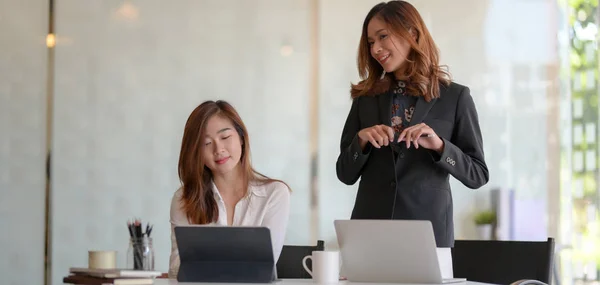 Duas jovens empresárias profissionais consultando o plano do projeto juntas na sala de escritório moderna — Fotografia de Stock