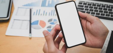 Ofiste boş ekran akıllı telefon kullanırken genç işadamının projesi üzerinde çalışırken çekilmiş görüntüleri. 