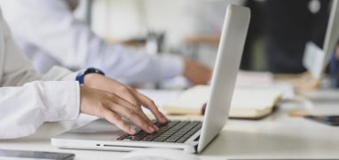 Modern ofis odasındaki projesinde çalışırken dizüstü bilgisayarında daktilo çeken iş kadını görüntüsü. 