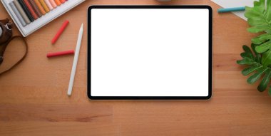 Model tabletli ve ahşap masadaki ofis malzemeleriyle modern tasarımcı işyerinin üst görüntüsü 