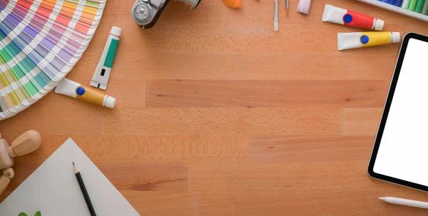 Overhead shot of comfortable artist studio with painting tools and office supplies on wooden table with copy space — ストック写真