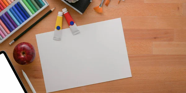 Top widok profesjonalnego miejsca pracy artysty z papieru szkicowego i narzędzi malarskich na drewnianym stole — Zdjęcie stockowe