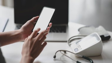 Ofis odasında boş ekran akıllı telefon kullanan genç profesyonel bir doktorun görüntüsü. 