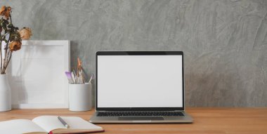 Moda bir iş yeri sahnesi. Laptop bilgisayarı ve ofis malzemeleri ahşap masa ve gri duvar arka planında. 