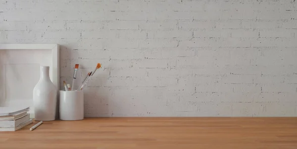 Cropped shot of comfortable workplace with office supplies and copy space on wooden table and brick wall background — 스톡 사진