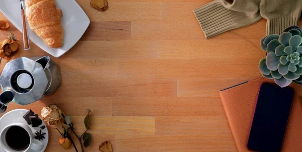 Vista superior do local de trabalho confortável com material de escritório e pequeno-almoço em fundo de mesa de madeira — Fotografia de Stock